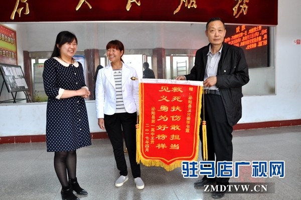 （圖二、縣衛(wèi)計委辦公室主任接過錦旗連聲說好?。?jpg